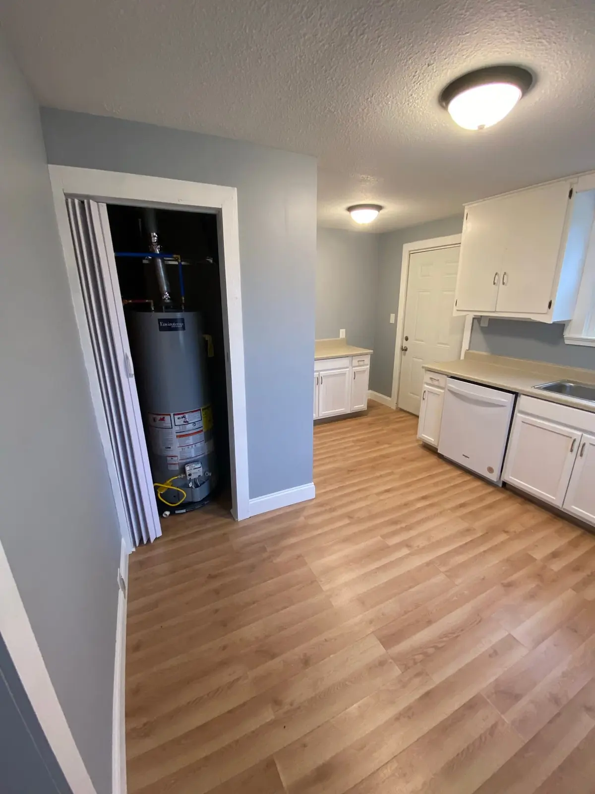 Finished ranch-house kitchen with white cabinets and new flooring